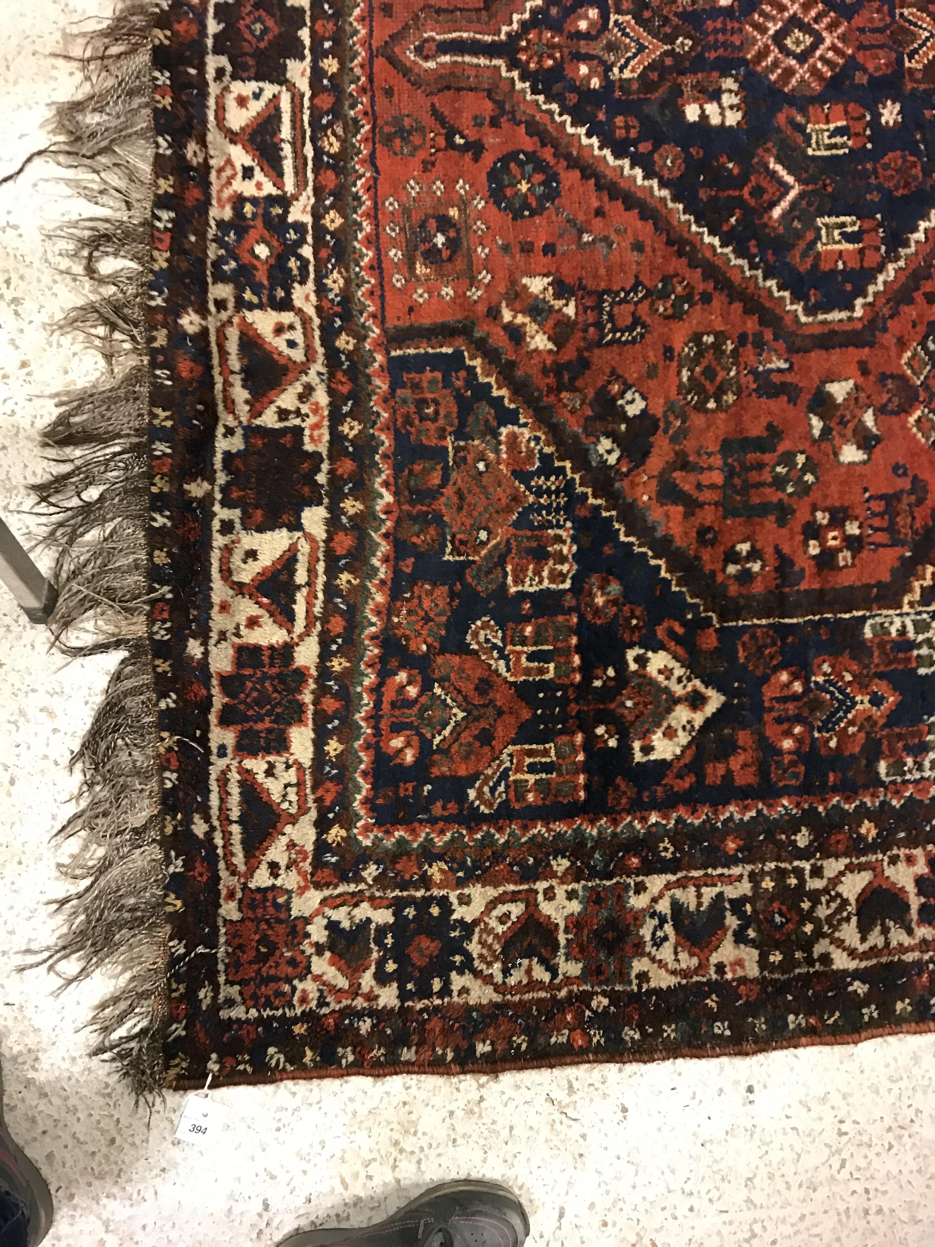 A Shiraz carpet, the central panel set with three joined diamond shaped medallions on a red and blue - Image 2 of 17