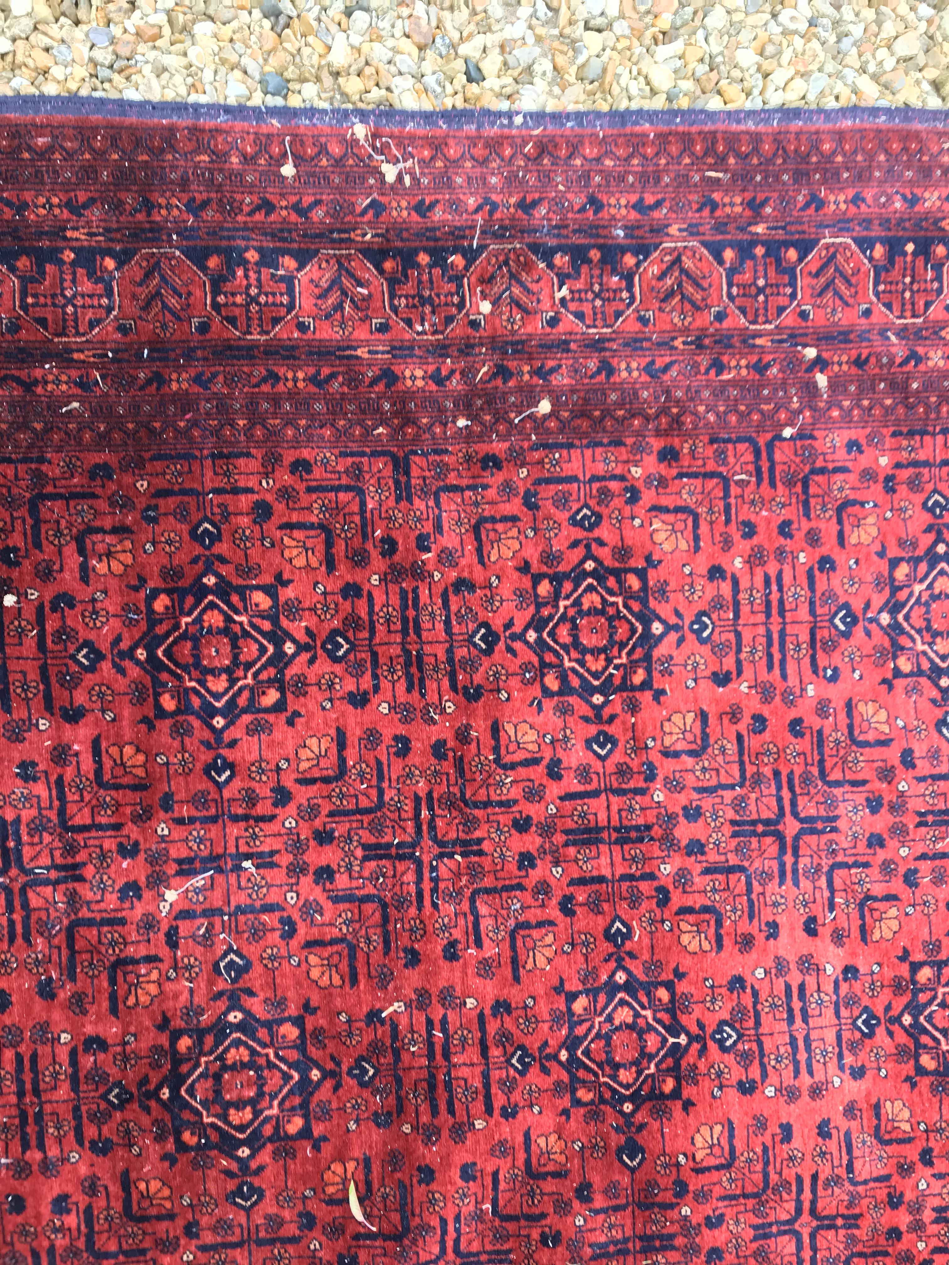 A Bokhara type carpet, the central panel set with repeating medallions on a dark red and black - Image 12 of 23