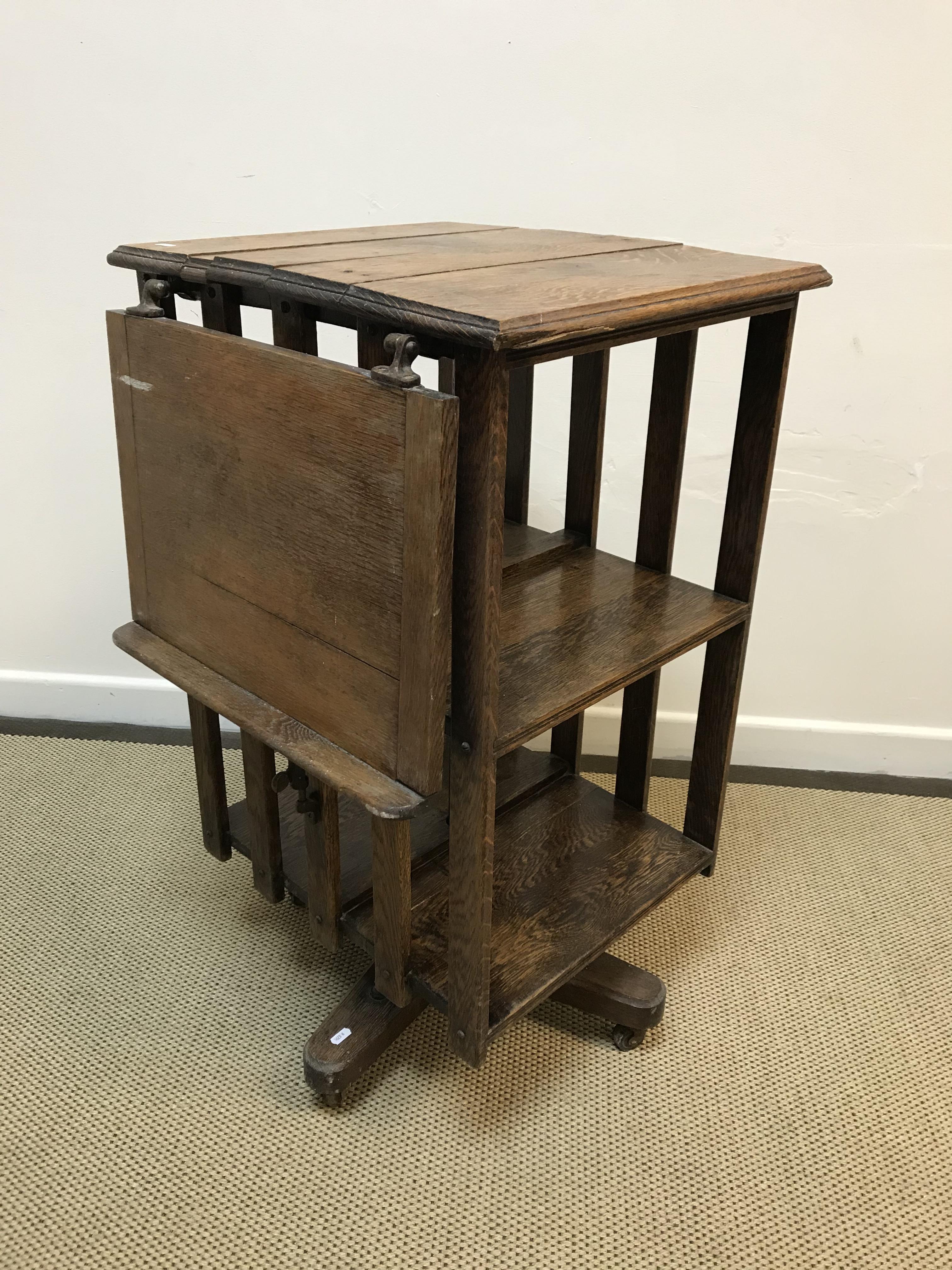A Victorian oak revolving bookcase with side reading slope over slatted sides on a cruciform base to - Image 3 of 5