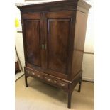 A 19th Century mahogany and yew wood cupboard, the moulded cornice above two fielded panelled