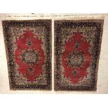 A pair of fine Oriental rugs, the central panels set with floral decorated circular medallion on a