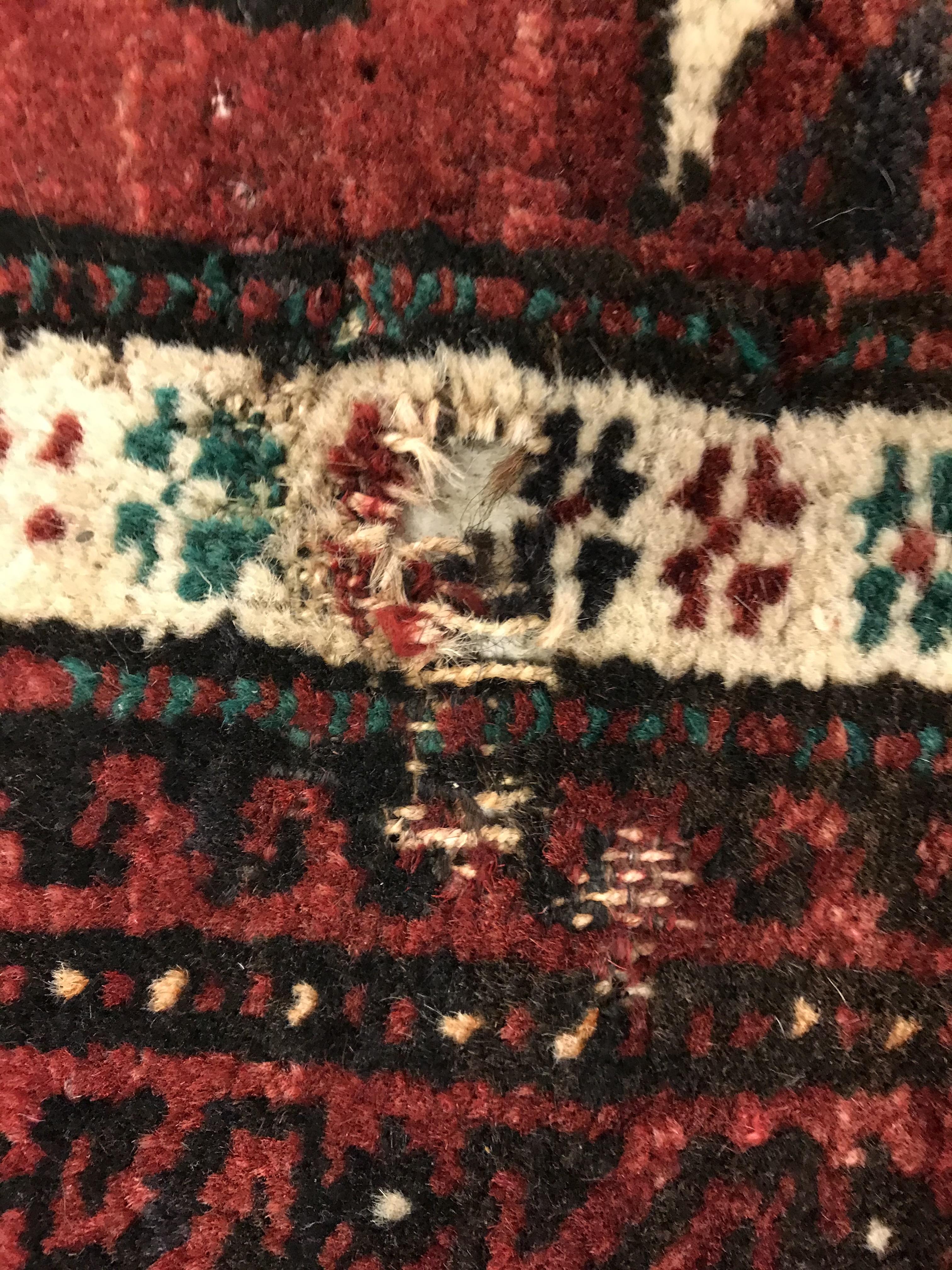 A Caucasian carpet, the central panel set with repeating medallion decoration on a blood red - Image 14 of 15