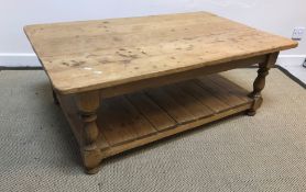 A modern pine coffee table, the plain top on turned legs united by an undertier, 122 cm wide x 75.