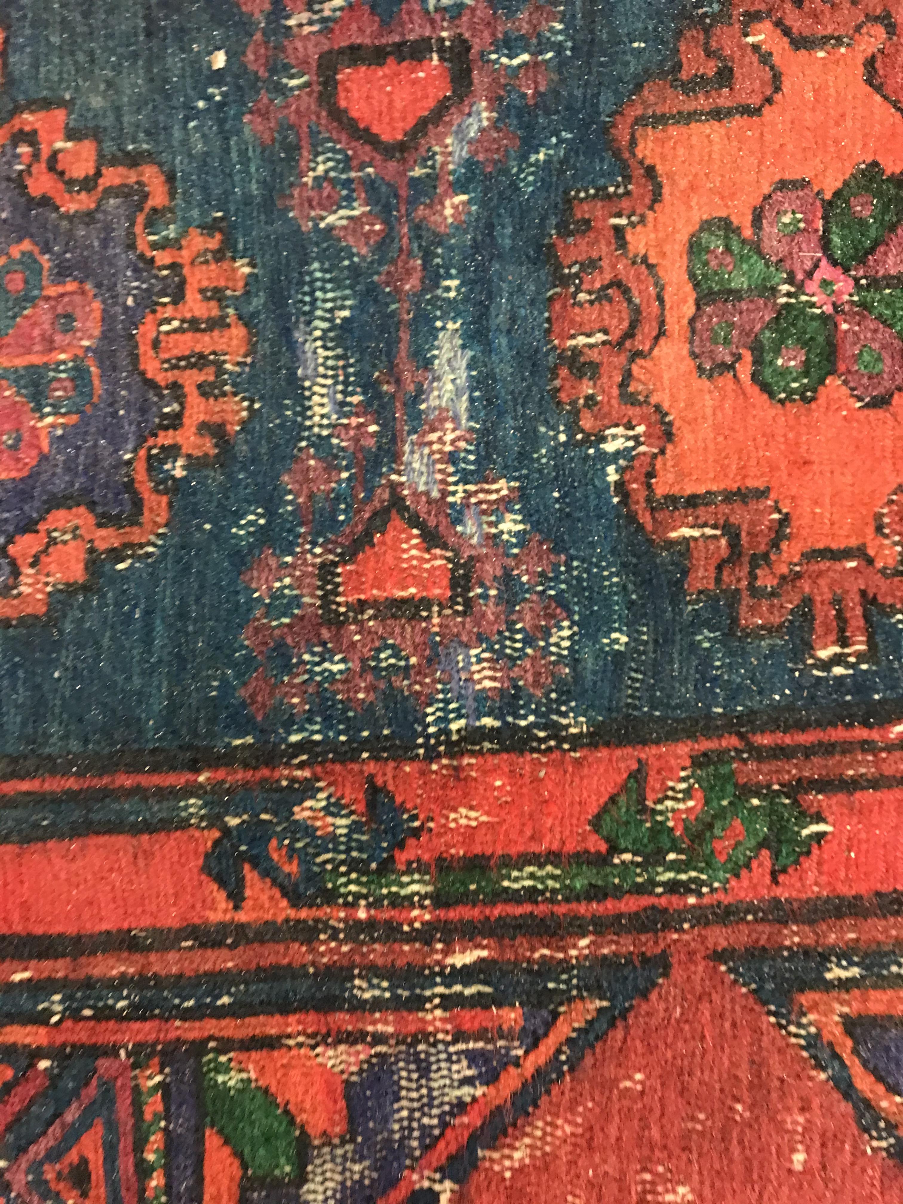 A Persian rug with three repeating lozenge medallions on a red and blue ground, within a blue, red - Image 13 of 20