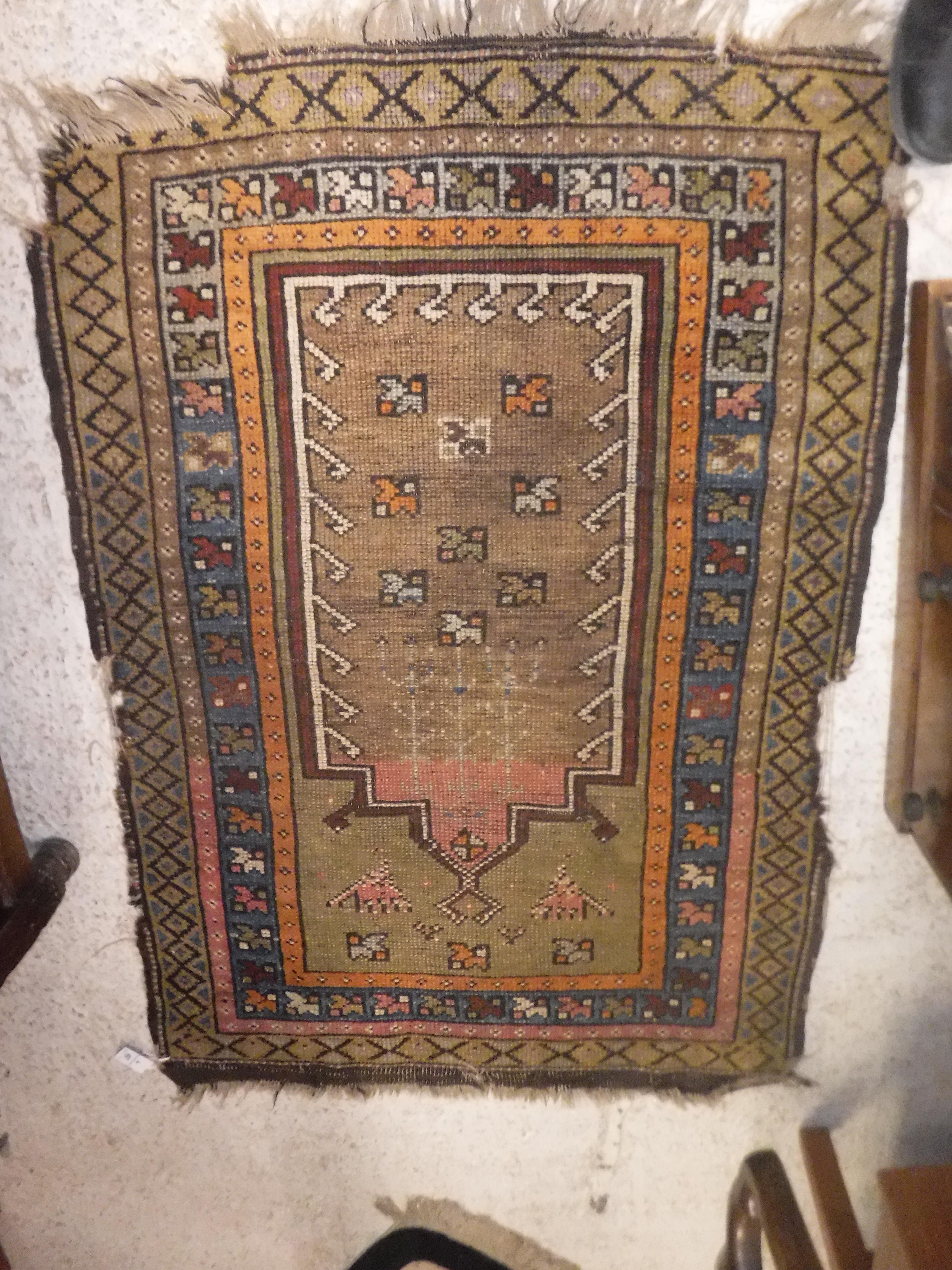 An Ushak prayer rug, the central panel on a green ground, within a stepped orange, blue and mushroom