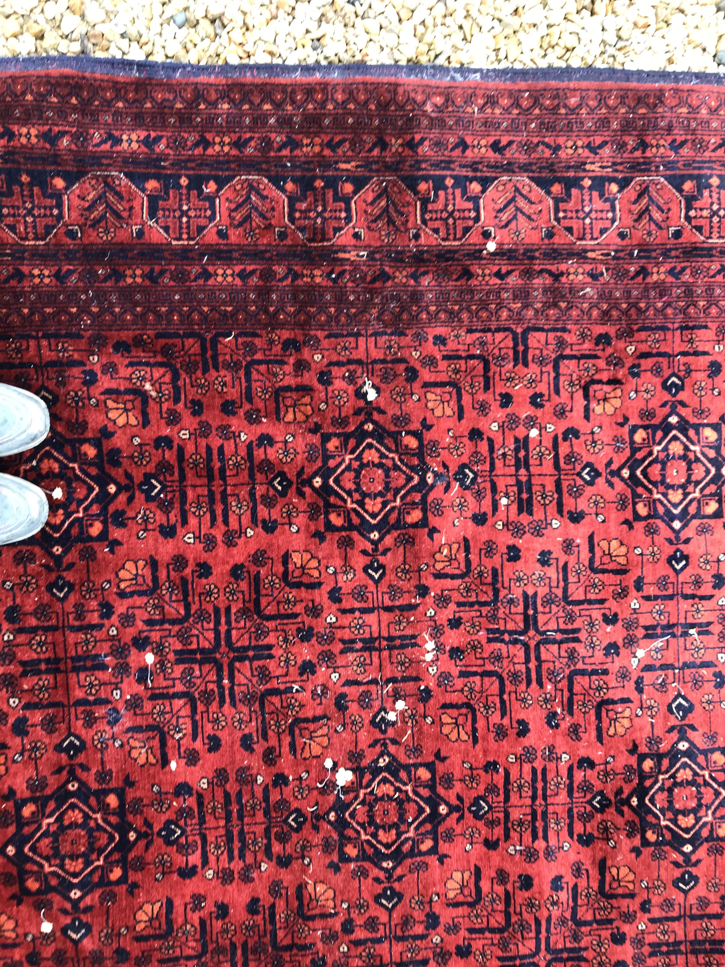 A Bokhara type carpet, the central panel set with repeating medallions on a dark red and black - Image 7 of 23