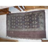 A Bokhara Juval rug, the main panel set with stylised elephant foot medallions on an aubergine