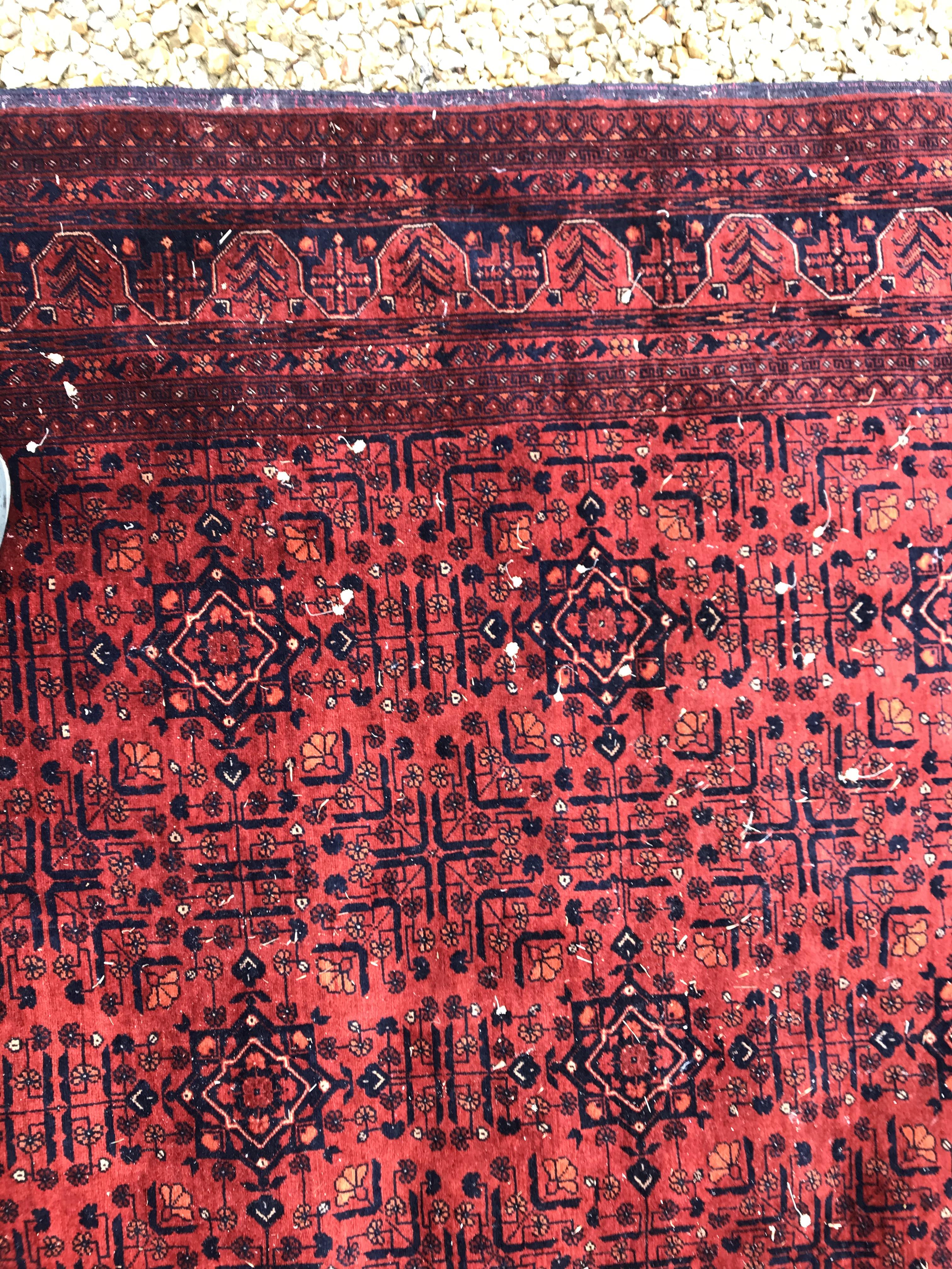 A Bokhara type carpet, the central panel set with repeating medallions on a dark red and black - Image 13 of 23
