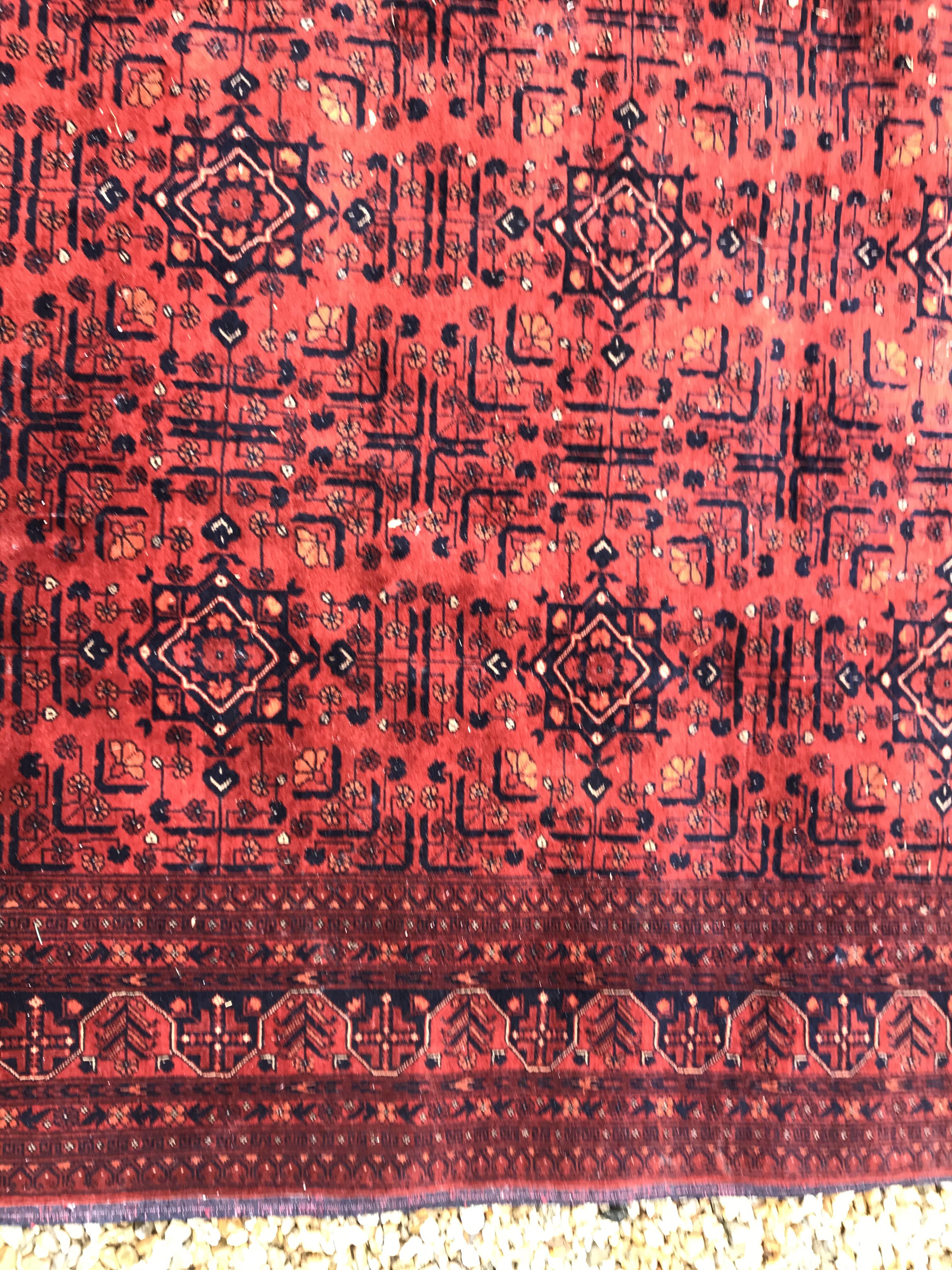 A Bokhara type carpet, the central panel set with repeating medallions on a dark red and black - Image 14 of 23