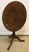 A 19th Century oak tea table, the circular snap top on a turned pedestal to hipped tripod base, 70