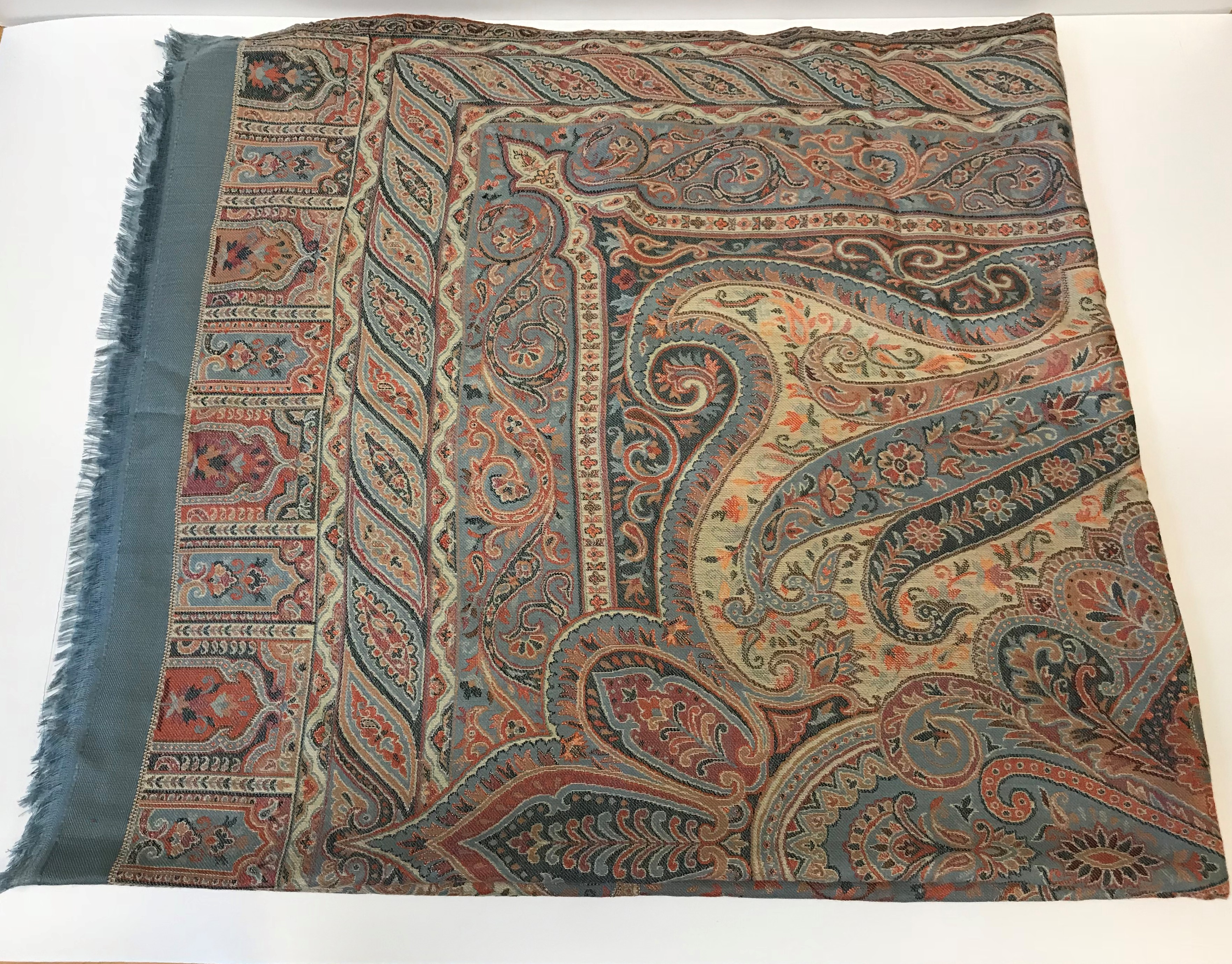 A large cotton shawl of Persian carpet style design, the centre medallion on a pale blue scrolling