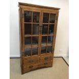 A 20th Century Chinese elm display cabinet with two glazed doors over two short and one long
