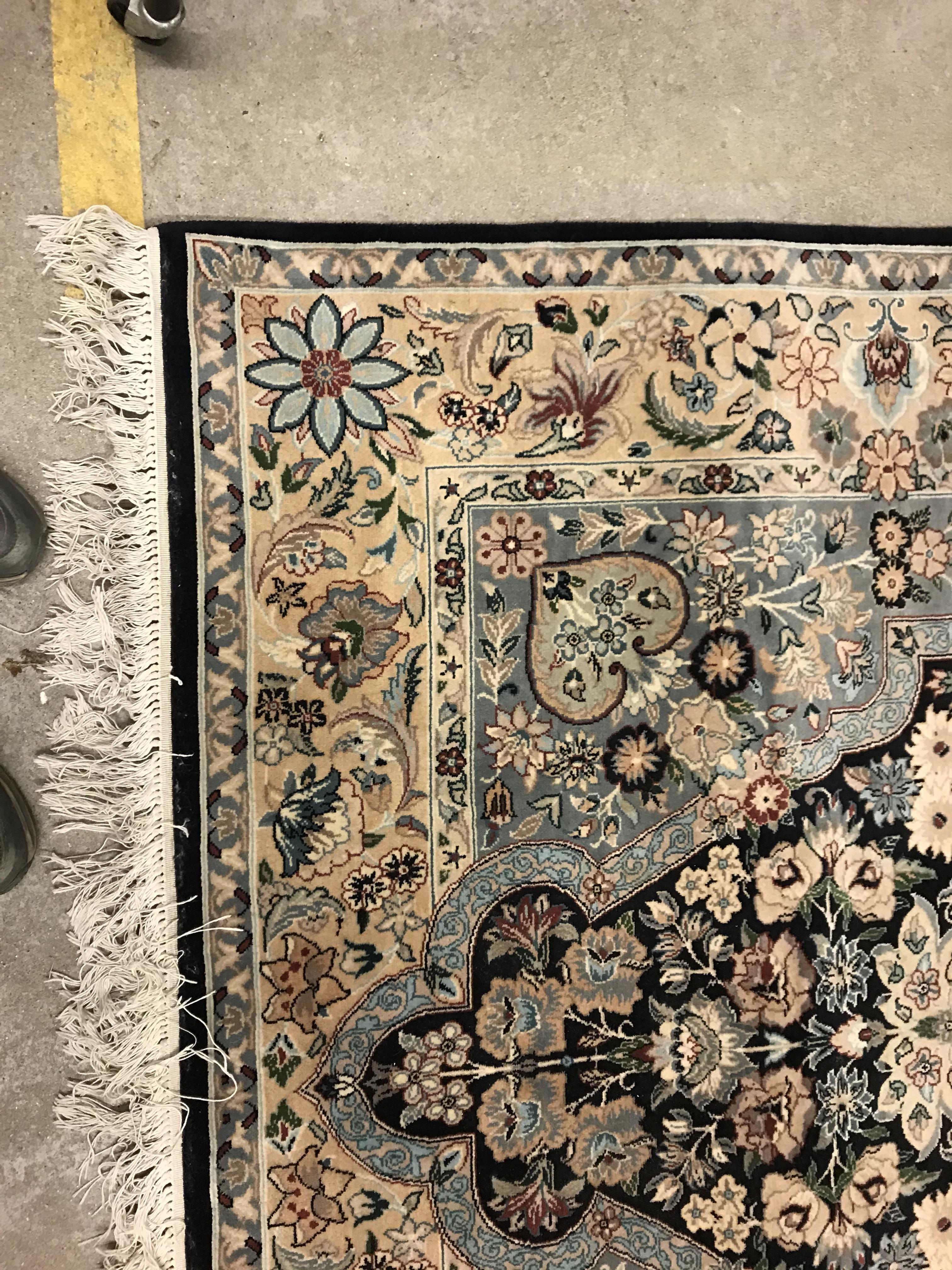 A Persian rug, the central panel set with floral decorated oval medallion on a dark blue and pale - Image 2 of 10