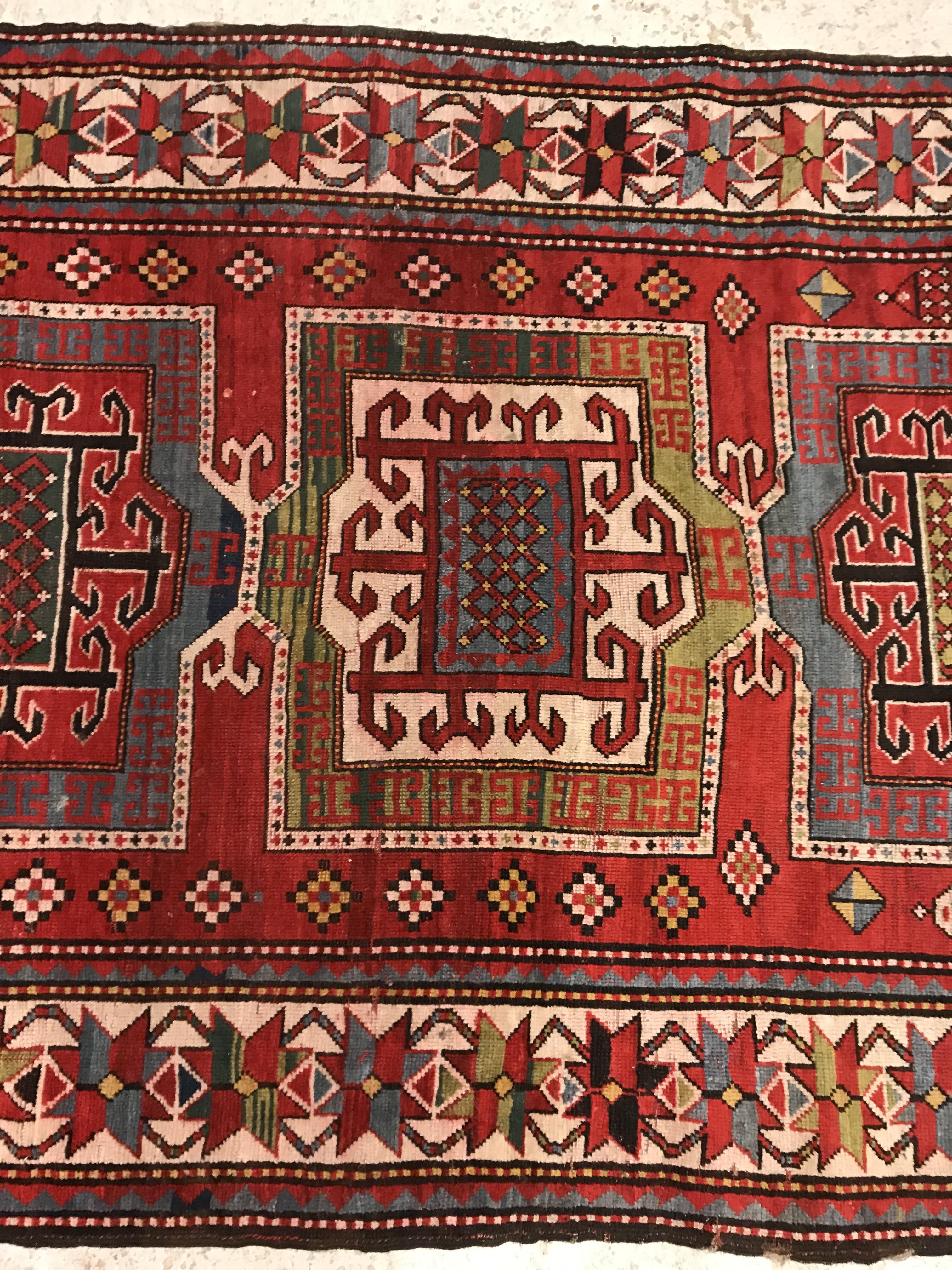 A Kasak runner, the central panel set with three repeating square medallions on a red ground - Image 3 of 10