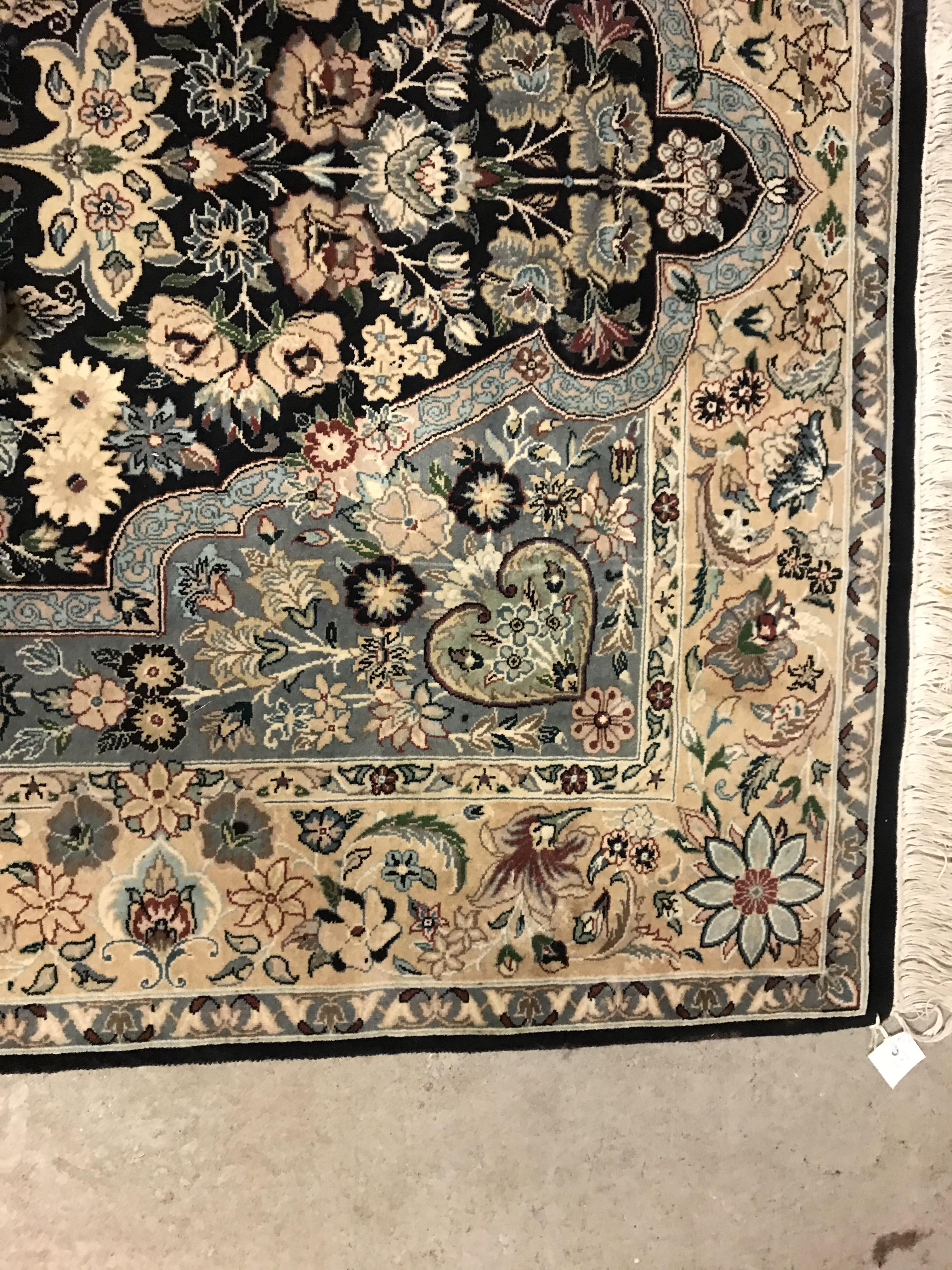 A Persian rug, the central panel set with floral decorated oval medallion on a dark blue and pale - Image 8 of 10