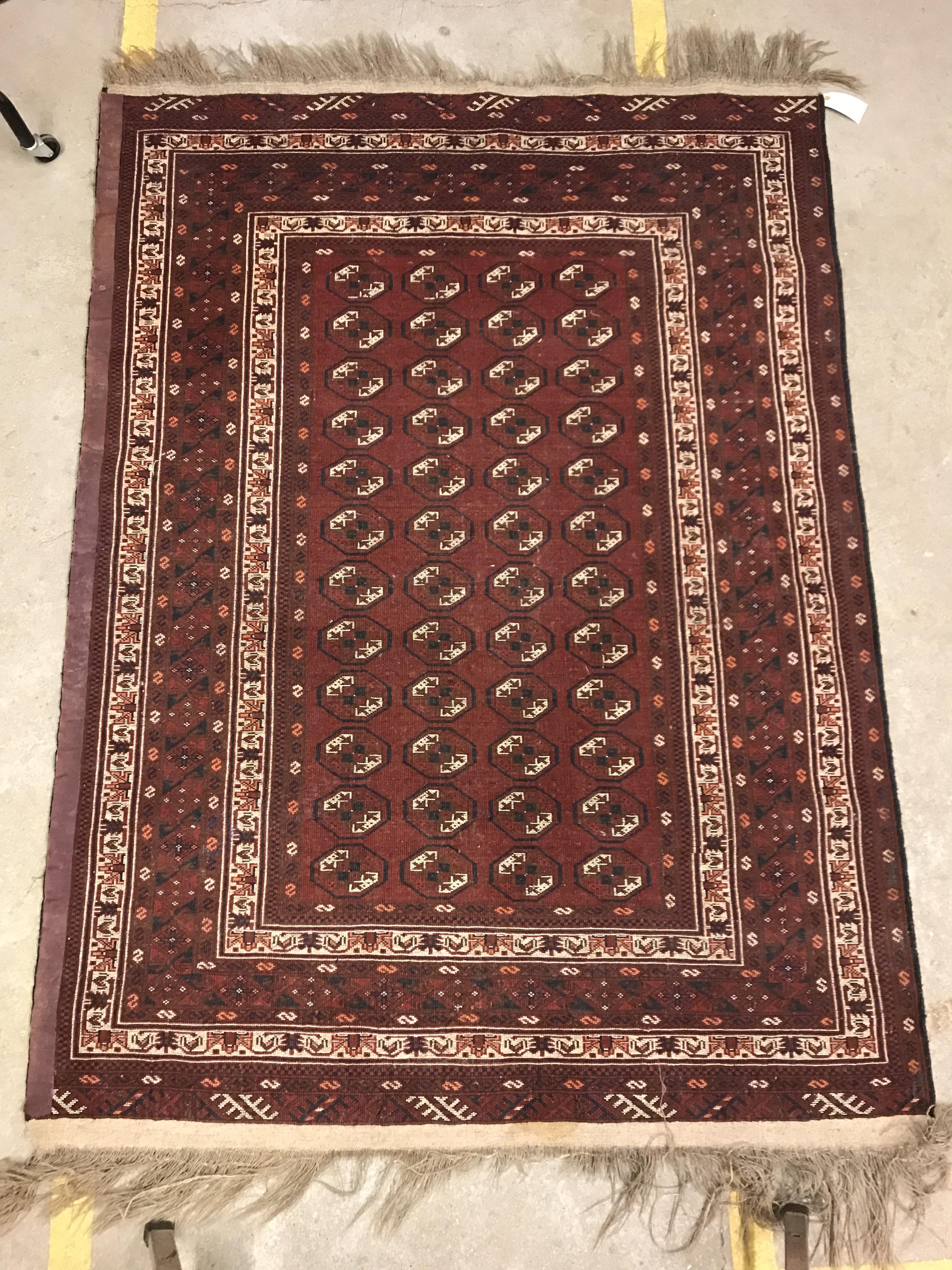 A Bokhara rug, the central panel set with repeating elephant foot style medallions on a dark red - Image 12 of 12