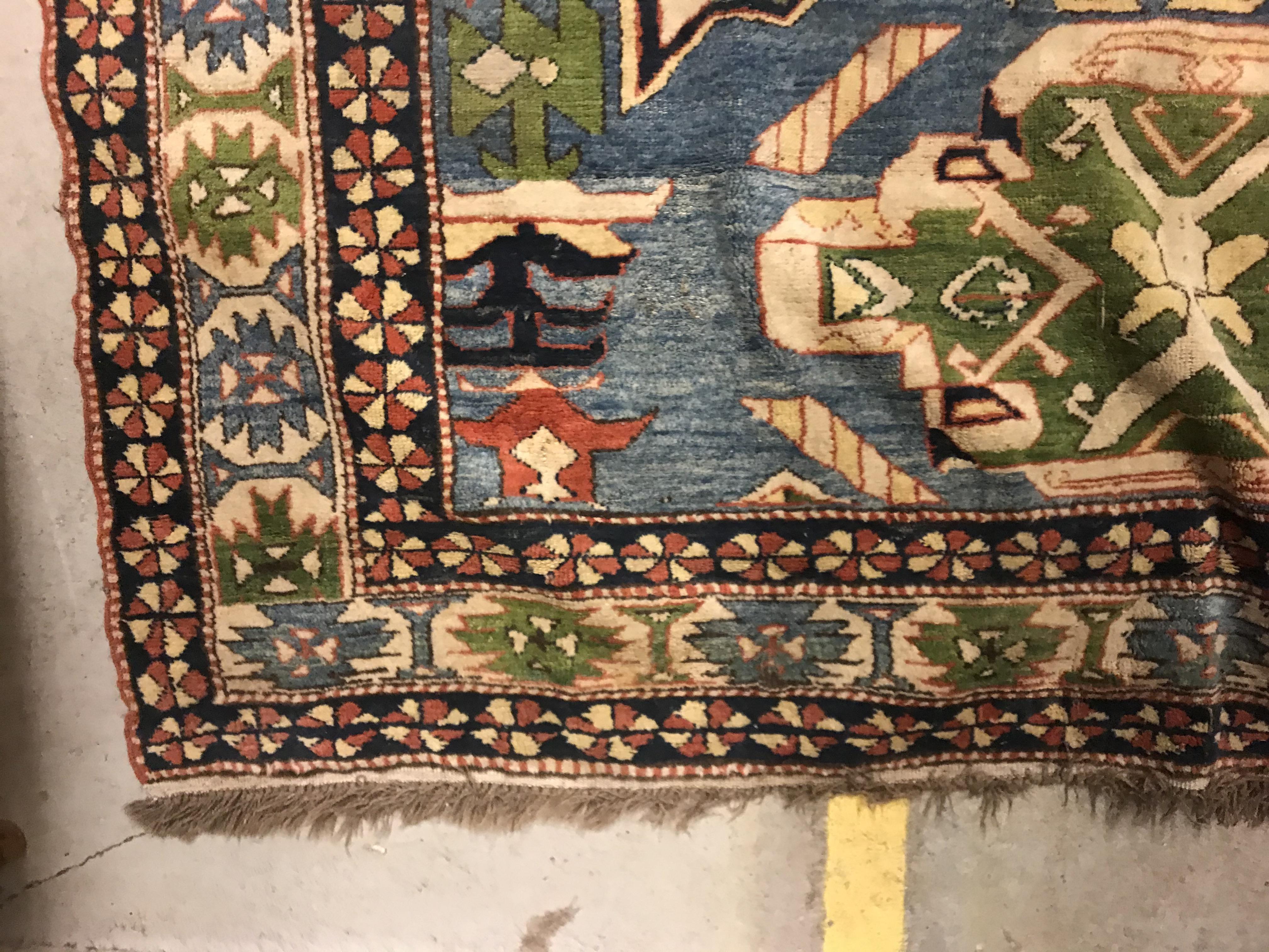 A Caucasian rug, the central panel set with three repeating medallions on a pale blue ground, within - Image 8 of 33