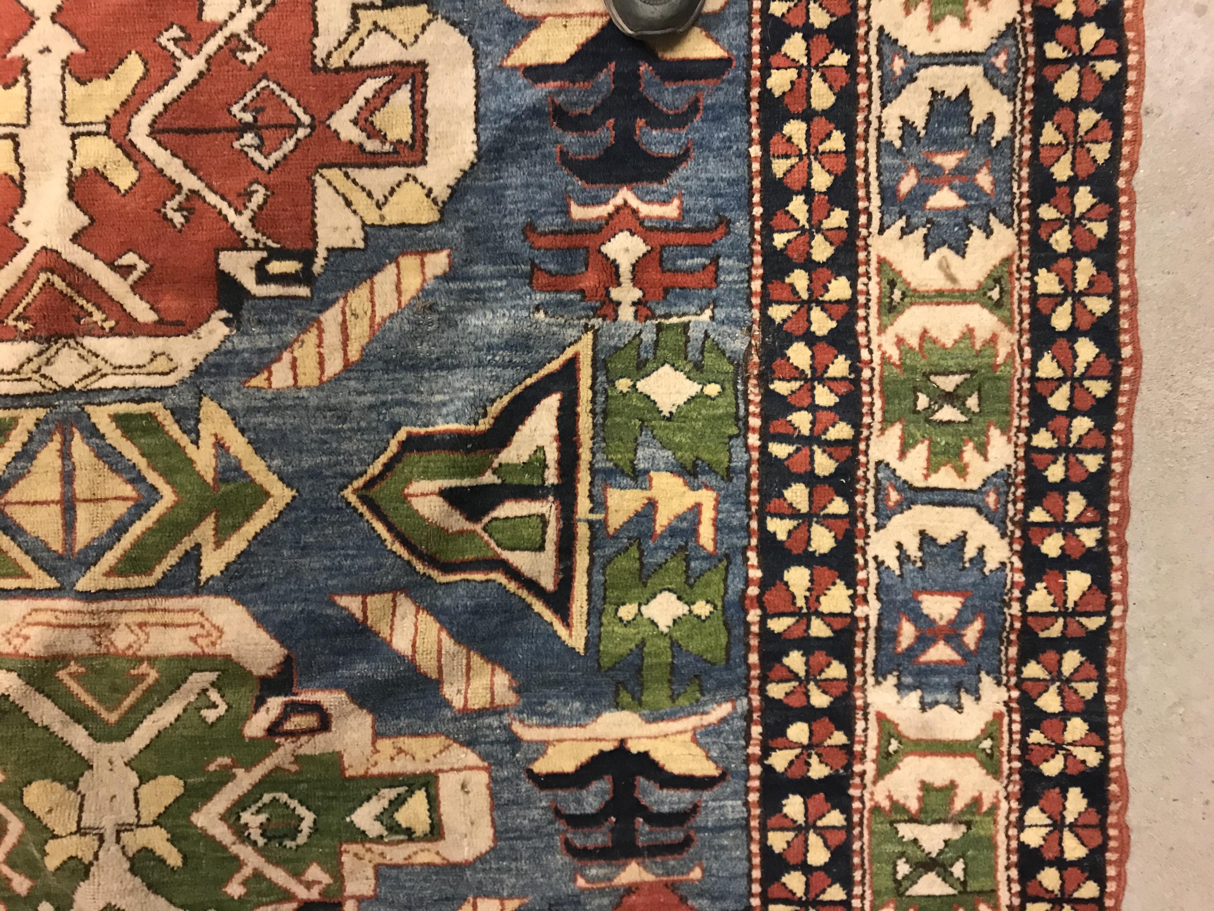 A Caucasian rug, the central panel set with three repeating medallions on a pale blue ground, within - Image 6 of 33