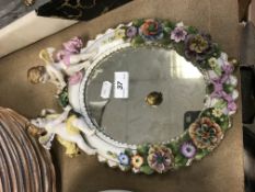 A Sitzendorf porcelain mirror, the oval plate within a frame decorated with floral encrustations and