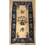 A 1950's Chinese rug, the central panel set with floral sprays and bird decoration on a cream
