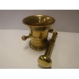 A 19th Century brass mortar of typical form with ring decorated flared rim and two lug handles,