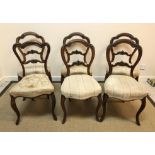 A set of five Victorian walnut standard salon chairs with upholstered seats on moulded cabriole