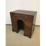 A 19th Century walnut kneehole desk in the early 18th Century manner, the quartered feather-banded