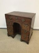 A 19th Century walnut kneehole desk in the early 18th Century manner, the quartered feather-banded