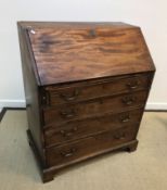 A late George III mahogany bureau, the plain top over a sloping fall enclosing a fitted interior