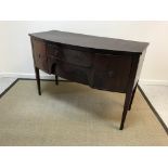 An Edwardian mahogany bow fronted sideboard, the plain top with cross-banded edging over two central