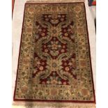 A Chobli rug, the central panel set with foliate decoration on a burgundy gorund, within a stepped