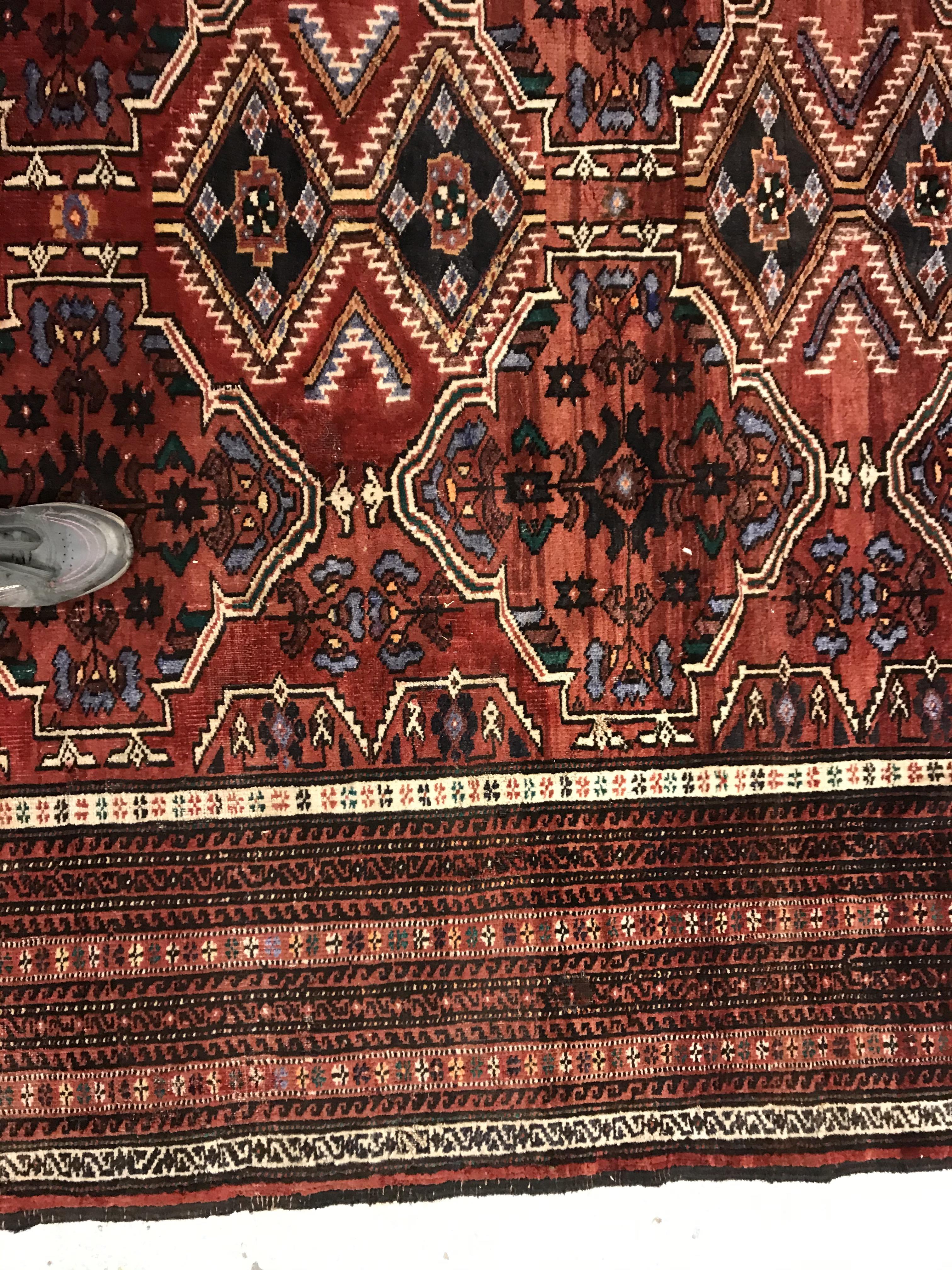 A Caucasian carpet, the central panel set with repeating medallion decoration on a blood red - Image 5 of 15