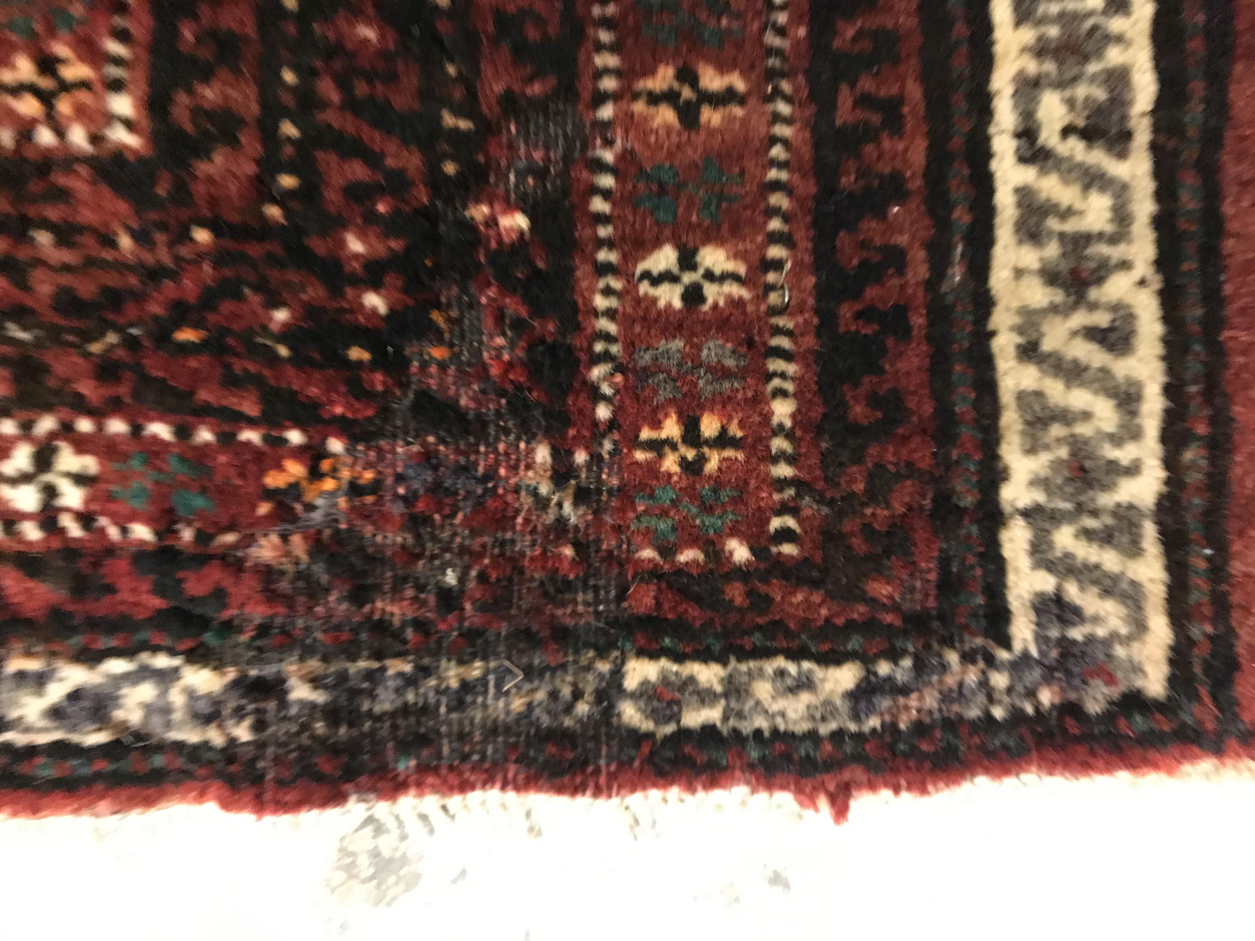 A Caucasian carpet, the central panel set with repeating medallion decoration on a blood red - Image 11 of 15
