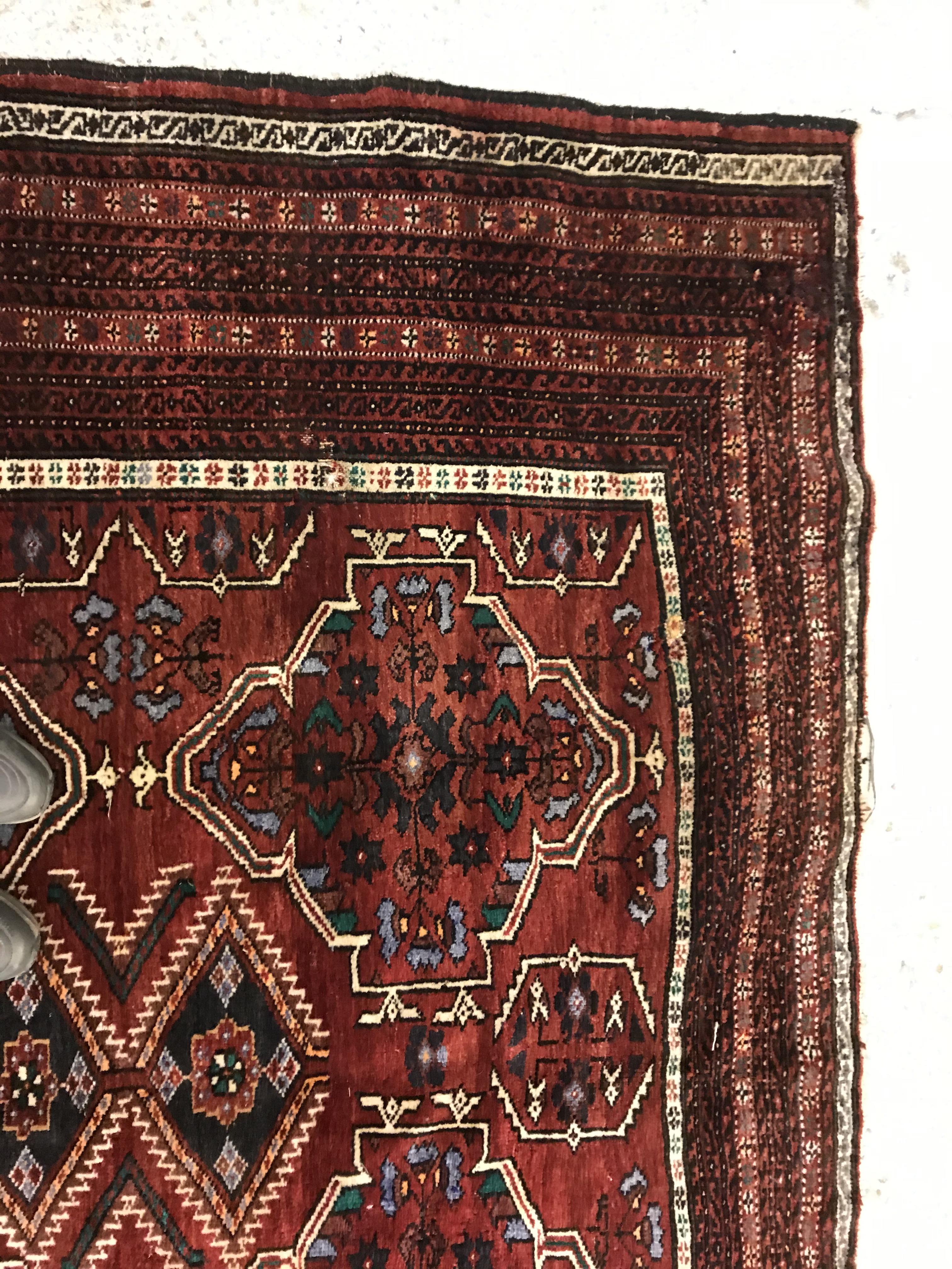 A Caucasian carpet, the central panel set with repeating medallion decoration on a blood red - Image 8 of 15