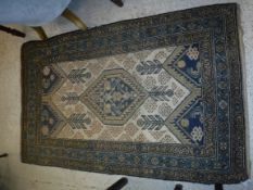 A Caucasian rug, the central panel set with lozenge shaped medallion on a cream ground, with