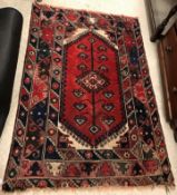 A Shiraz rug, the central panel set with lozenge shaped medallion on a red and cream ground within a