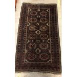 A Belouch tribal rug, the central panel set with repeating elephant foot style medallions on a