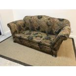 An early 20th Century floral upholstered double drop arm two seat sofa on squat square feet, 168