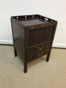 A late George III mahogany night table, the tray top with pierced medallion decoration over a