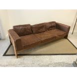 A mid 20th Century oak framed brown leather upholstered three seat sofa in the Scandinavian taste,