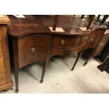 An Edwardian mahogany serpentine fronted sideboard in the George III taste, the plain top over two