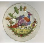 A Chelsea plate, the centre field decorated with an exotic bird in a landscape within a basket