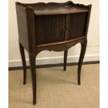 A French oak pot cupboard, the three quarter galleried top over two tambour doors and a shaped