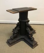 A Victorian carved walnut table base of octagonal form, raised on four gryphon carved platform