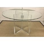 WITHDRAWN A modern circular glass top table on perspex X framed legs