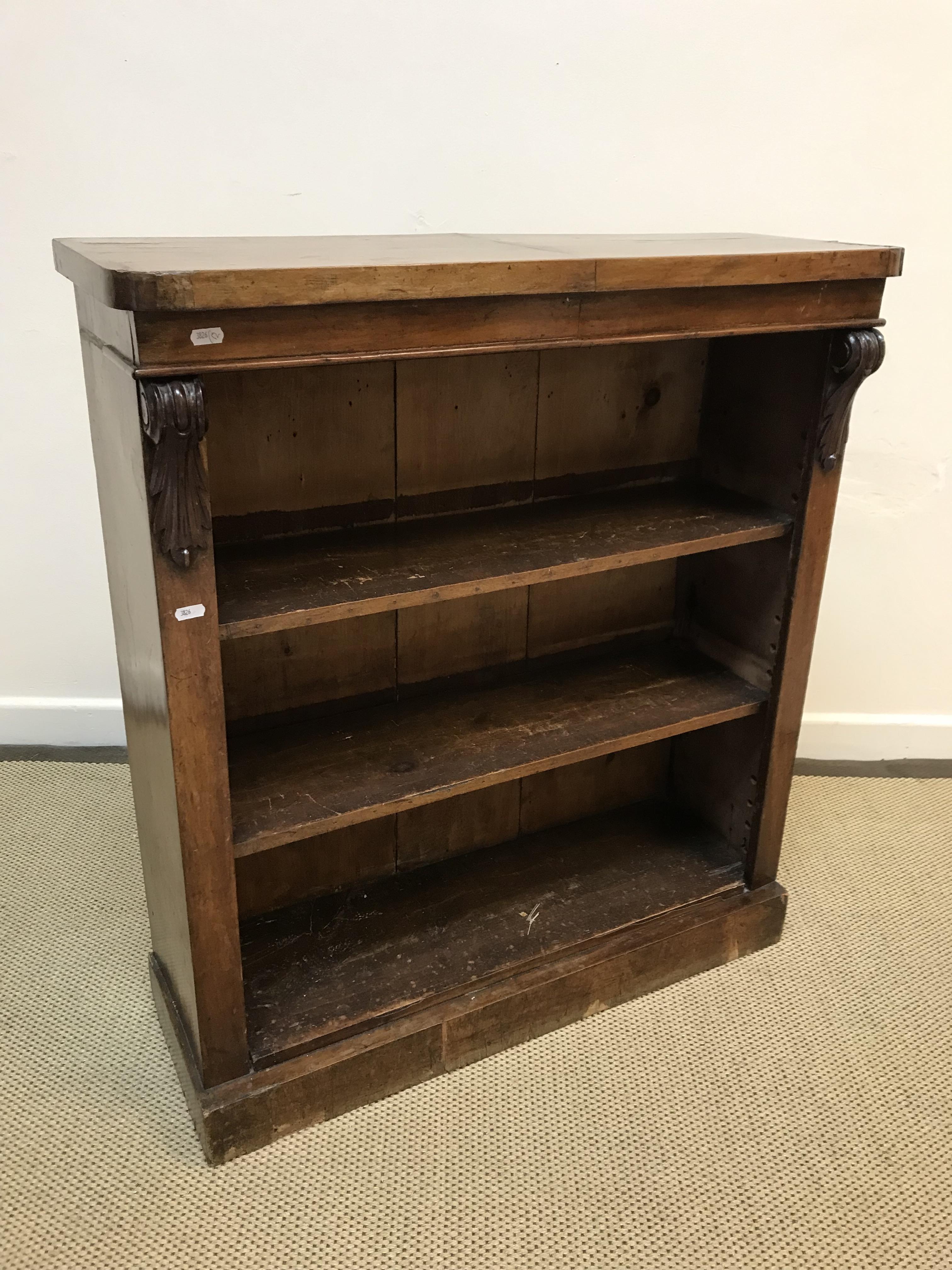 A Victorian mahogany open bookcase with scrolling foliate carved corbels on a plinth base, 83.5 cm