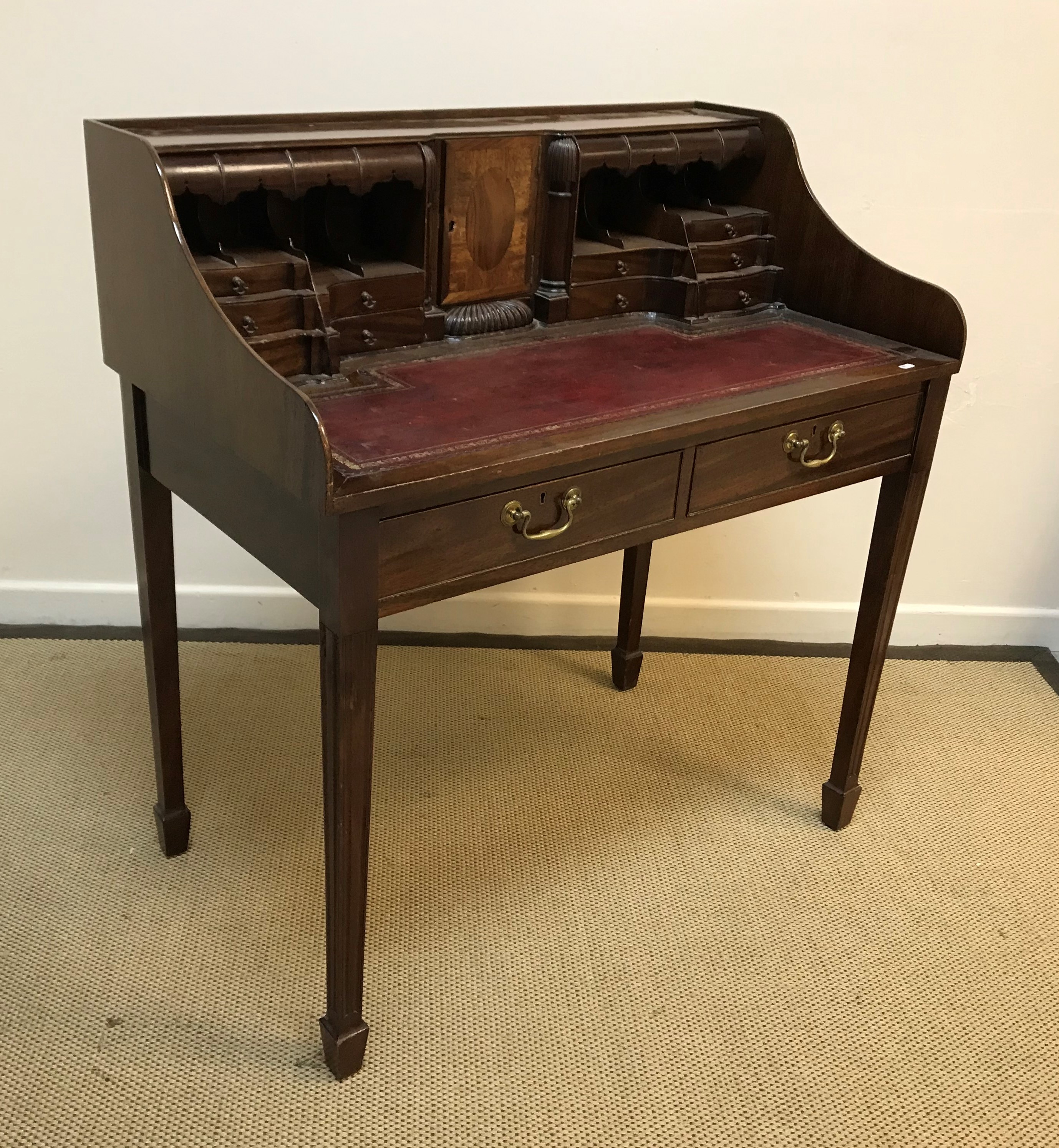 A mahogany ladies writing table in the Georgian style with central cupboard door flanked by