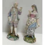 A pair of Derby-style figures of a gentleman and woman in mob cap, damaged and restored to the shell