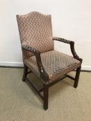 A mahogany framed and upholstered open arm chair in the George III style