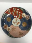 A circa 1900 Japanese Arita charger, the centre field decorated with panels of children in